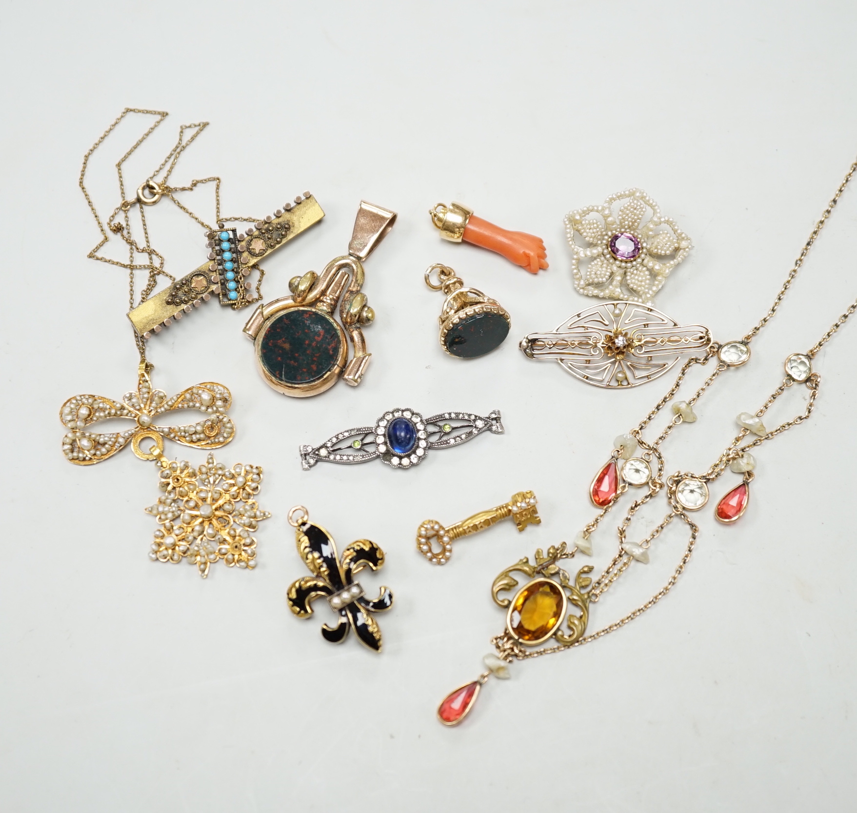 A small group of antique and later jewellery, including 9ct gold and bloodstone fob seal, a 1930's yellow metal and seed pearl set key brooch, 14k and black enamel brooch, spinning fob pendant, coral hand charm, 10k and